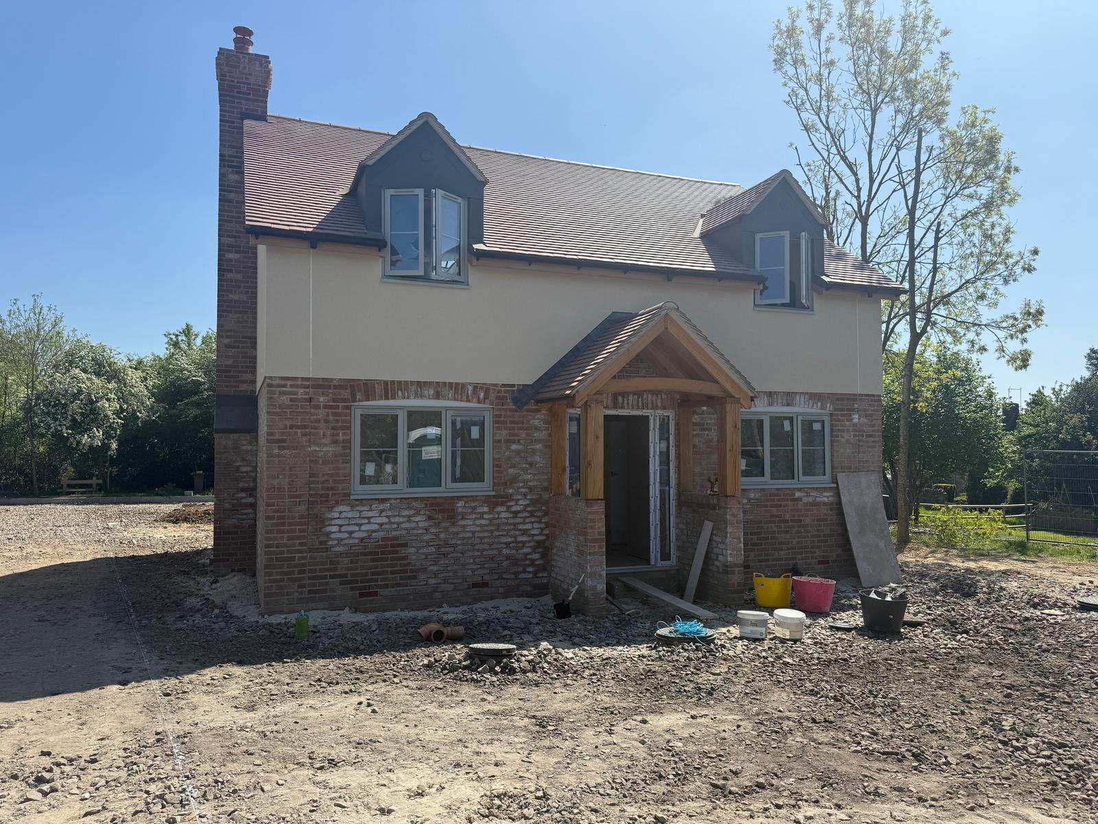 Detached new build property with render and brickwork, red tiled roof alternative angle