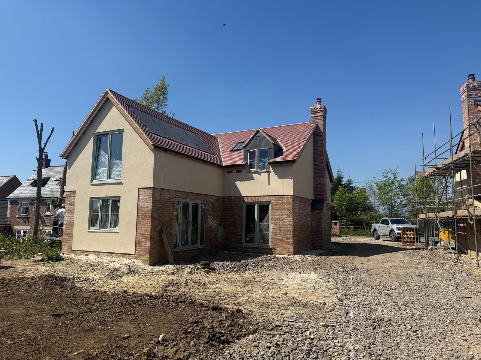 Detached new build property with render and brickwork, red tiled roof alternative angle